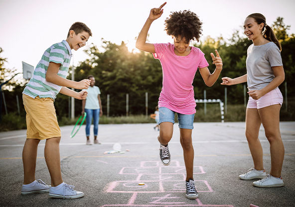 Three preteen's playing hopscotch