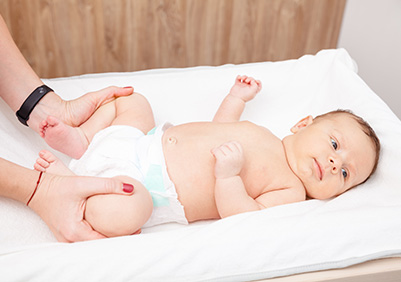 Female pediatrician showing exercise for hip dysplasia prevention on two months baby boy
